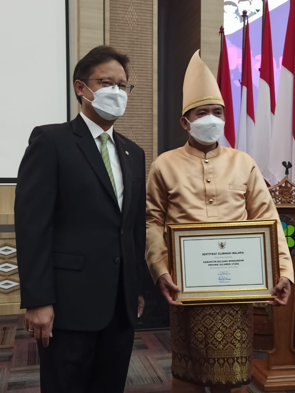 Asisten II Pemkab Bolmong Zainudin Paputungan (kanan) saat menerima penghargaan dari Menkes RI.